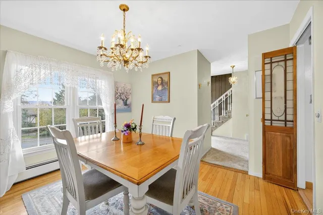 a dining room with furniture a chandelier and wooden floor