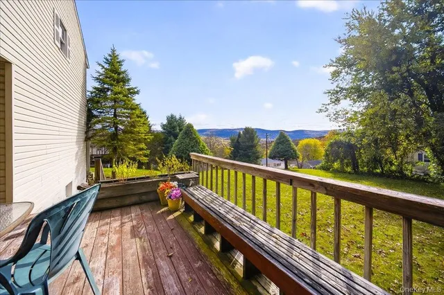 a view of a balcony with wooden floor and outdoor seating