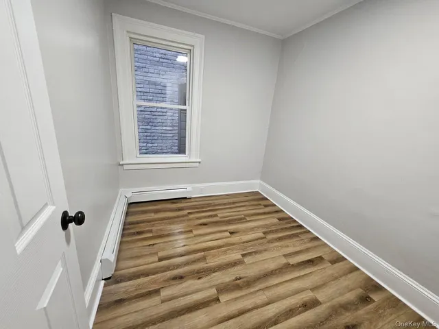 a view of a room with wooden floor and window
