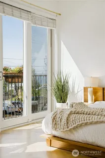 a view of a living room with a large window and potted plants