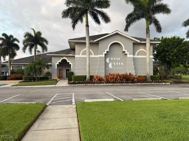 a front view of a house with a garden and palm trees