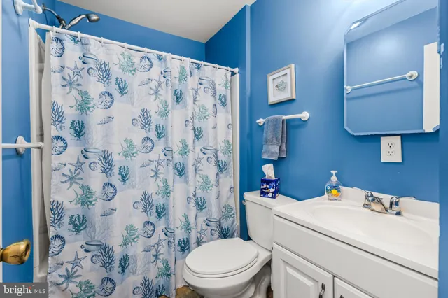 a bedroom with a bed a chandelier and a dresser