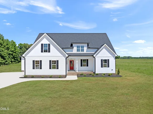 a front view of a house with a garden and yard