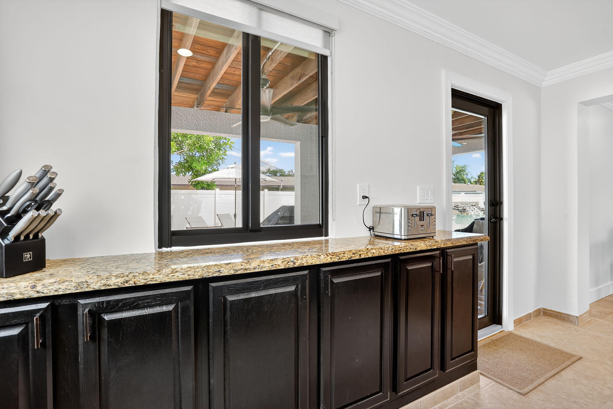 2840 Northeast 7th Terrace Pompano Beach, FL 33064 - Photo 11 of 42 a kitchen with granite countertop a sink and a window