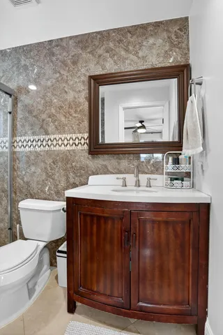 a bathroom with a sink vanity mirror and toilet