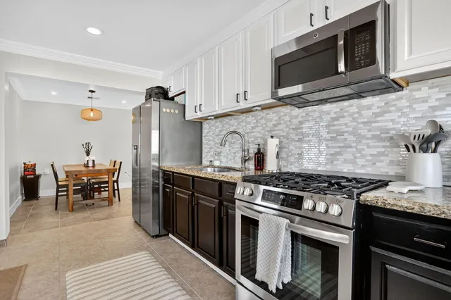 a kitchen with stainless steel appliances granite countertop a stove and a microwave