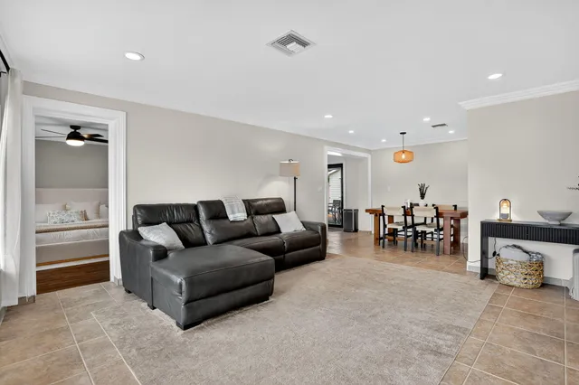 a living room with furniture and a dining table with wooden floor