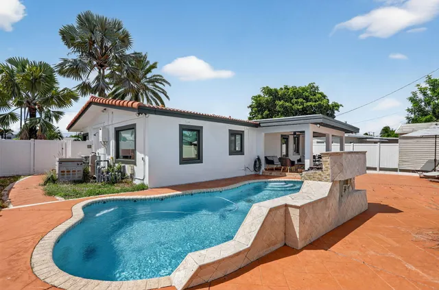 a view of a house with backyard and sitting area