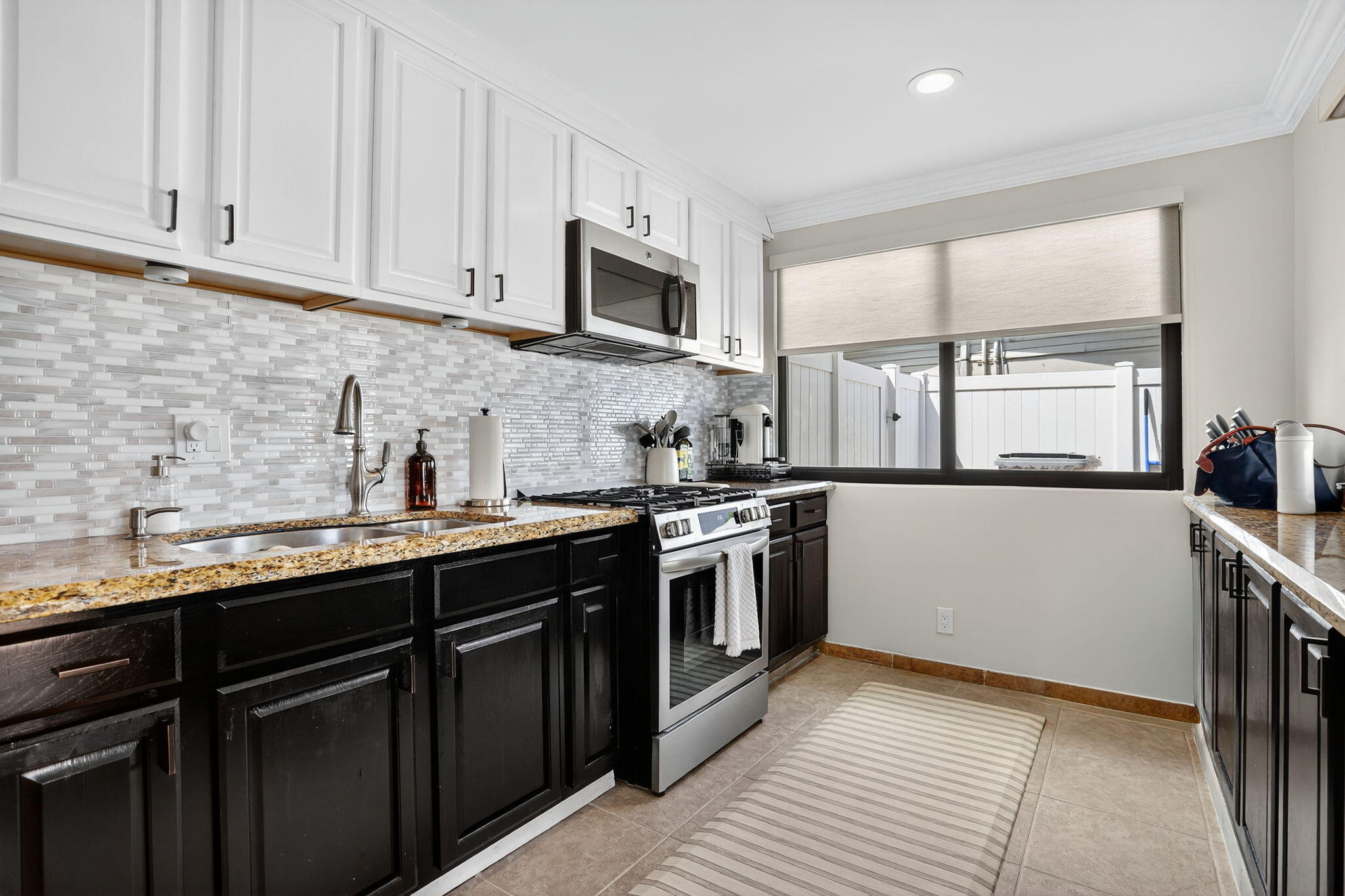 2840 Northeast 7th Terrace Pompano Beach, FL 33064 - Photo 10 of 42 a kitchen with stainless steel appliances granite countertop a sink stove and microwave