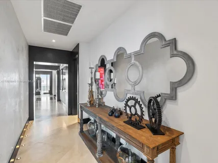 a living room with furniture a flat screen tv and floor to ceiling window
