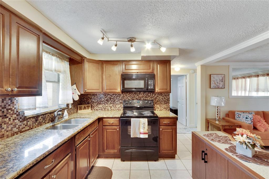 10801 Fillmore Avenue Port Richey, FL 34668 - Photo 16 of 29 a kitchen with stainless steel appliances granite countertop a sink stove and refrigerator