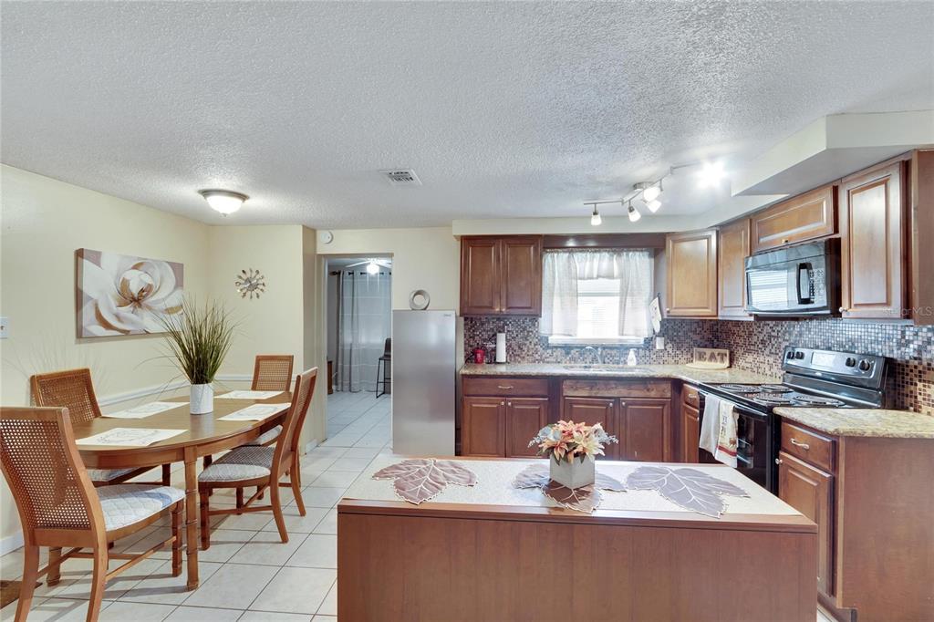 10801 Fillmore Avenue Port Richey, FL 34668 - Photo 18 of 29 a dining hall with stainless steel appliances granite countertop a dining table and chairs