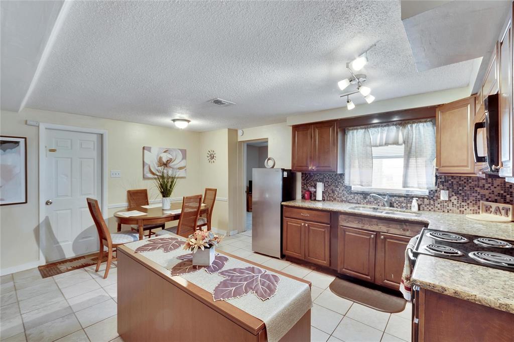 10801 Fillmore Avenue Port Richey, FL 34668 - Photo 20 of 29 a kitchen with stainless steel appliances granite countertop a sink stove and refrigerator