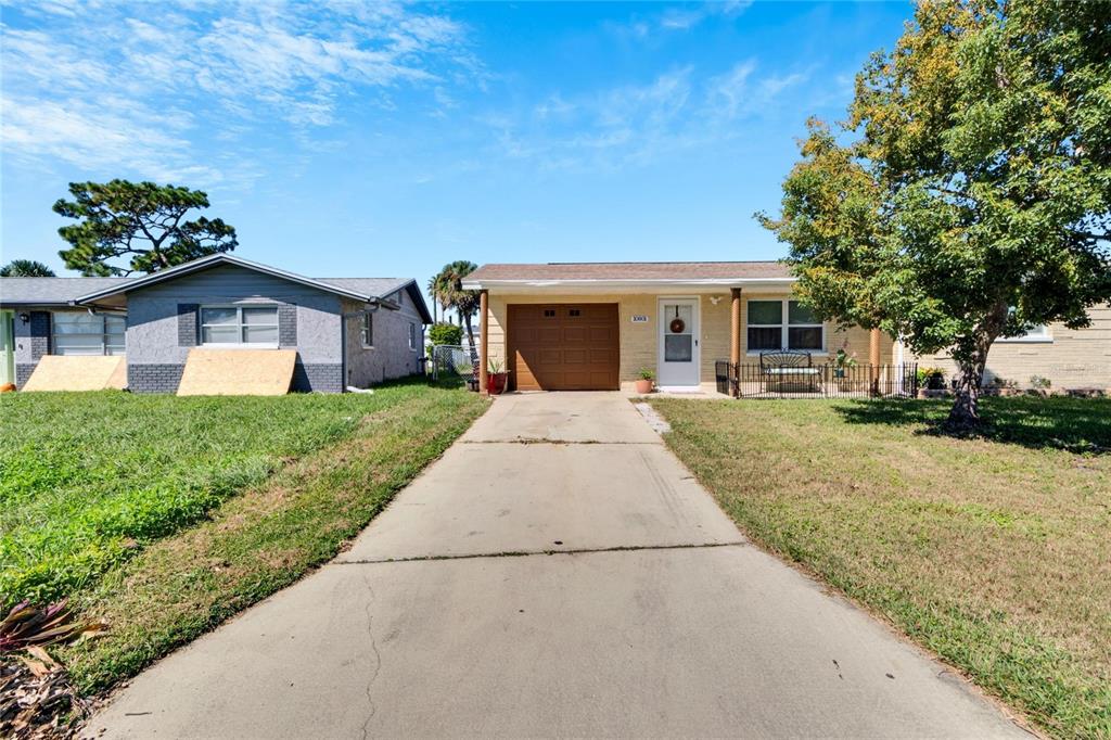 10801 Fillmore Avenue Port Richey, FL 34668 - Photo 2 of 29 a front view of a house with a yard and potted plants