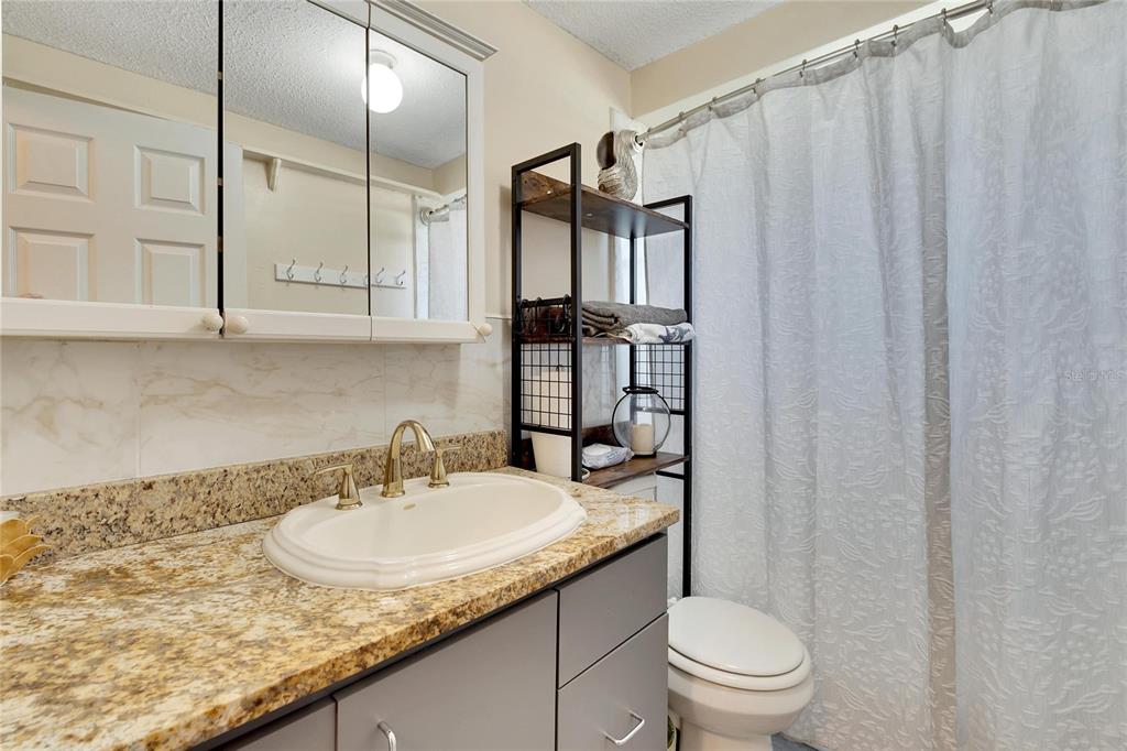 10801 Fillmore Avenue Port Richey, FL 34668 - Photo 23 of 29 a bathroom with a granite countertop sink and a mirror