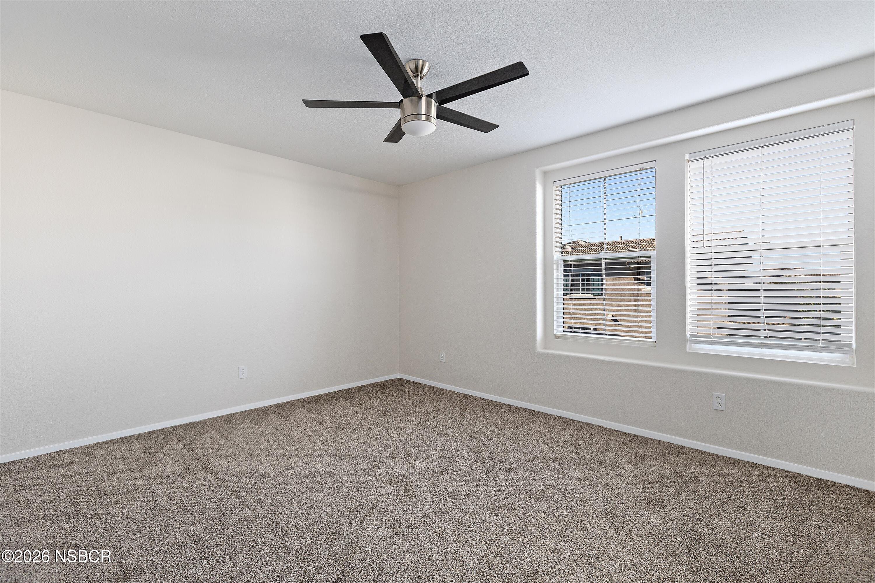 2020 Green Ridge Circle Lompoc, CA 93436 - Photo 13 of 20 an empty room with a ceiling fan and windows