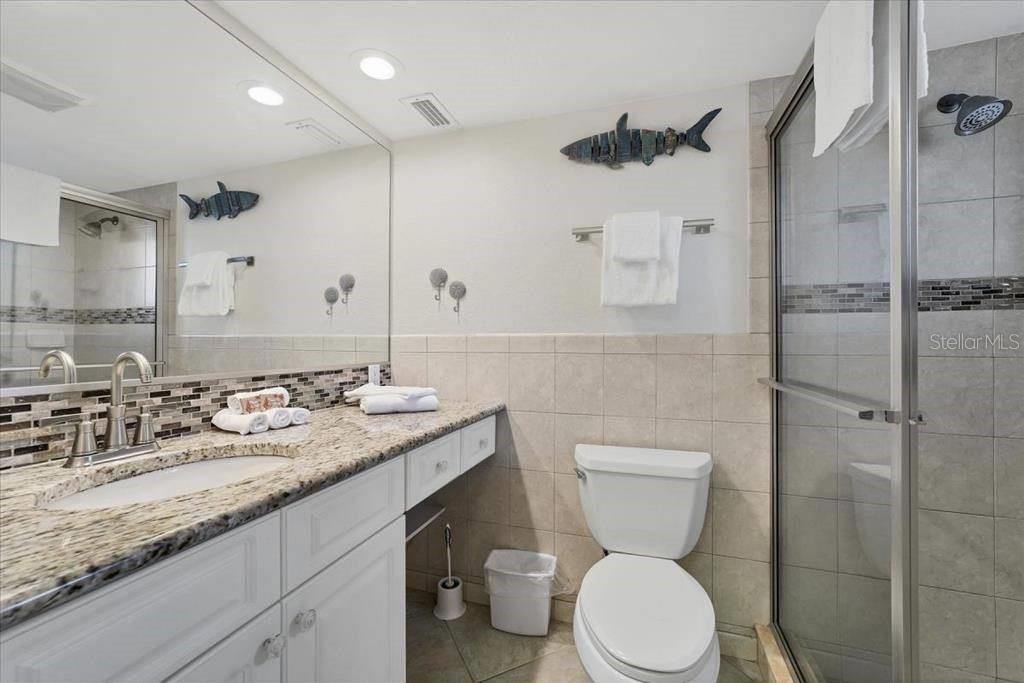 6154 Midnight Pass Road, Unit 102 Sarasota, FL 34242 - Photo 11 of 11 a bathroom with a toilet sink and shower
