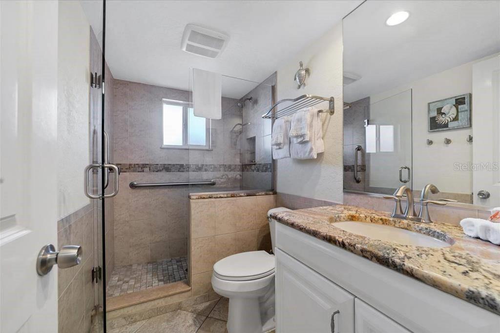 6154 Midnight Pass Road, Unit 102 Sarasota, FL 34242 - Photo 5 of 11 a bathroom with a granite countertop sink toilet and shower