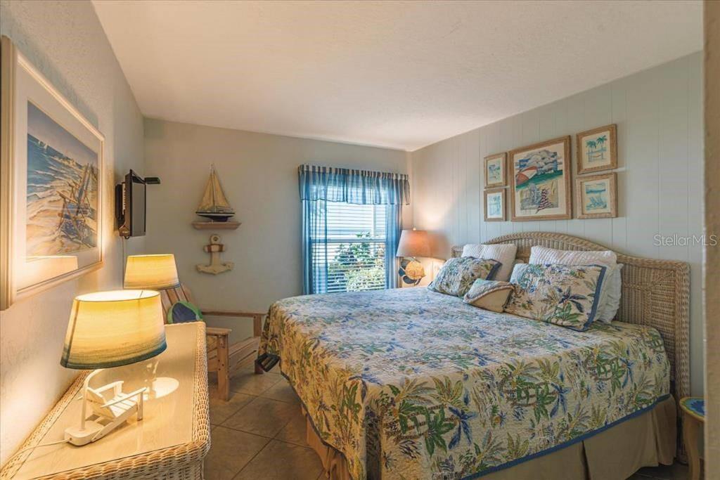 6154 Midnight Pass Road, Unit 102 Sarasota, FL 34242 - Photo 6 of 11 a bedroom with a bed and wooden floor