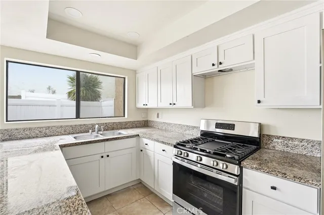 a white kitchen with stove top oven and sink
