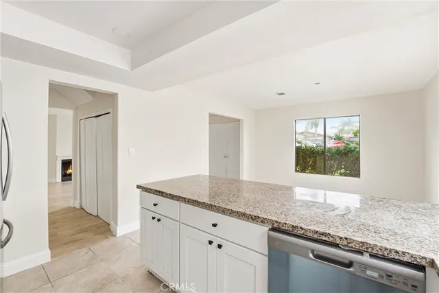 a kitchen with granite countertop cabinets stainless steel appliances a sink and a window