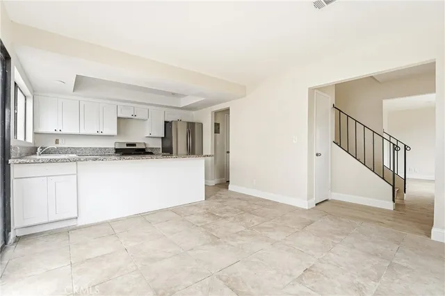 a view of kitchen with granite countertop cabinets and white appliances