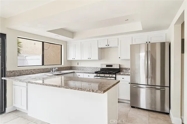 a kitchen with stainless steel appliances granite countertop a refrigerator sink stove and microwave