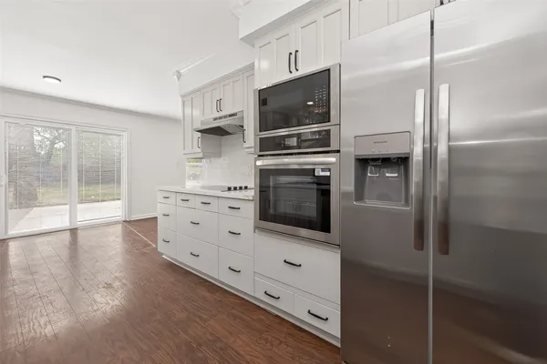 a kitchen with stainless steel appliances a refrigerator and a stove top oven