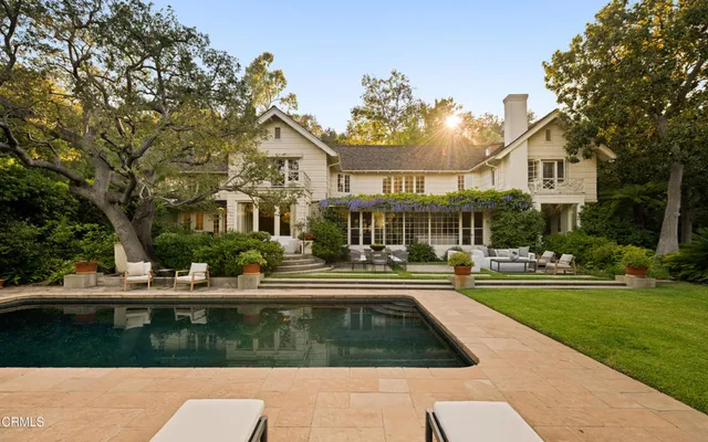 a front view of a house with swimming pool having outdoor seating