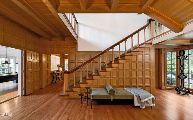 a living room with furniture stairs and a wooden floor