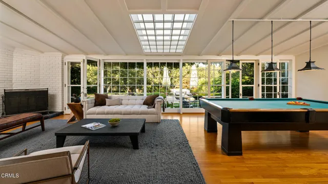 a living room with furniture a flat screen tv and a floor to ceiling window