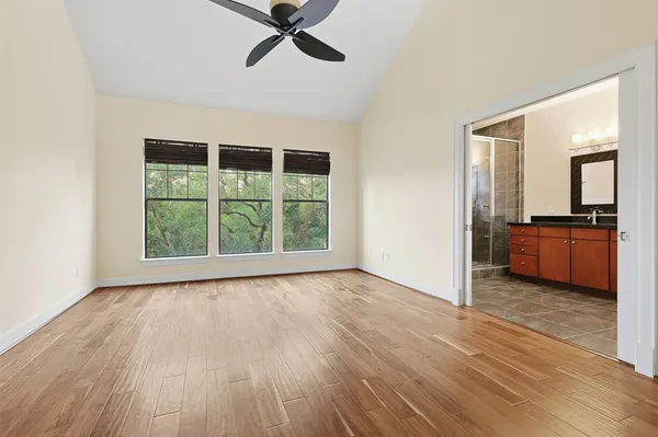 a view of an empty room with a window and wooden floor