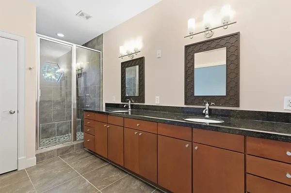 a bathroom with double vanity sinks and a mirror