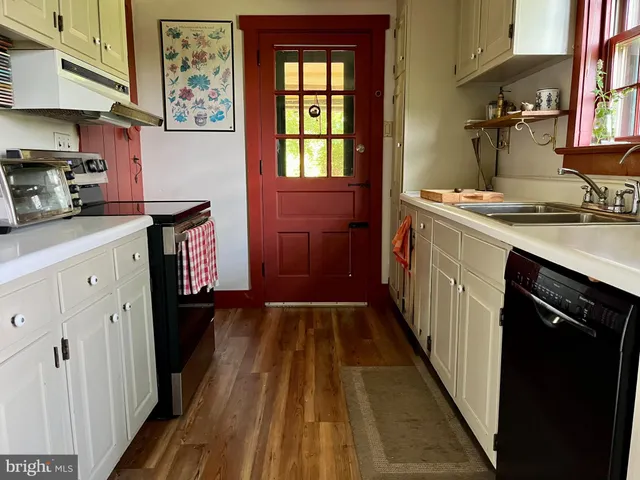 a kitchen with sink a refrigerator and window