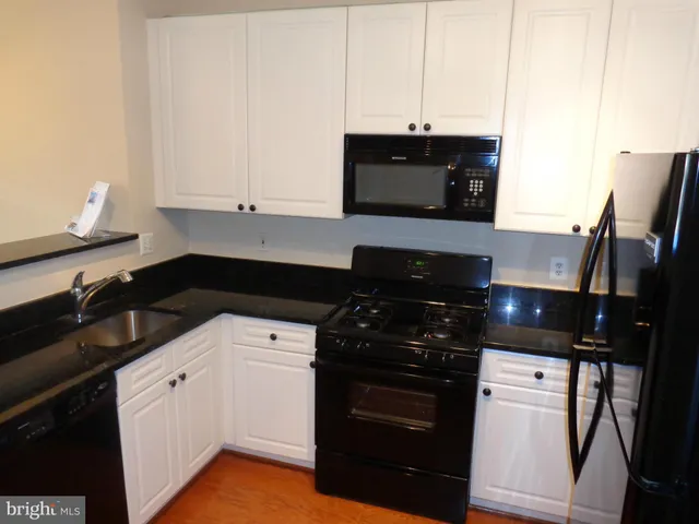 a kitchen with a sink and white cabinets