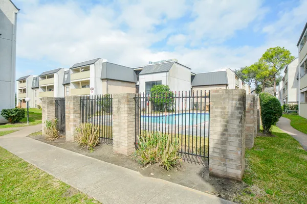 a view of a brick house with a big yard and potted plants