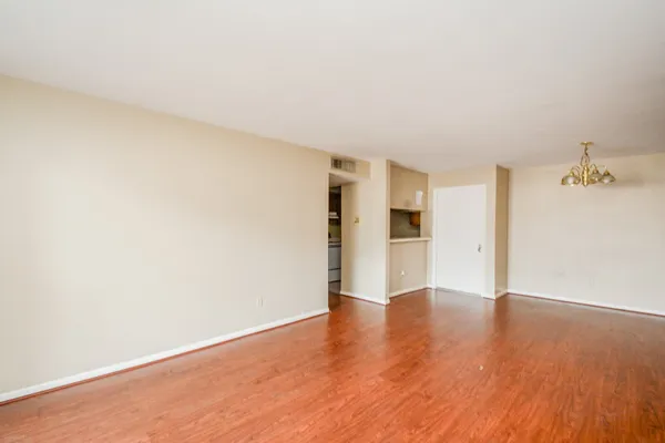 a view of an empty room with wooden floor