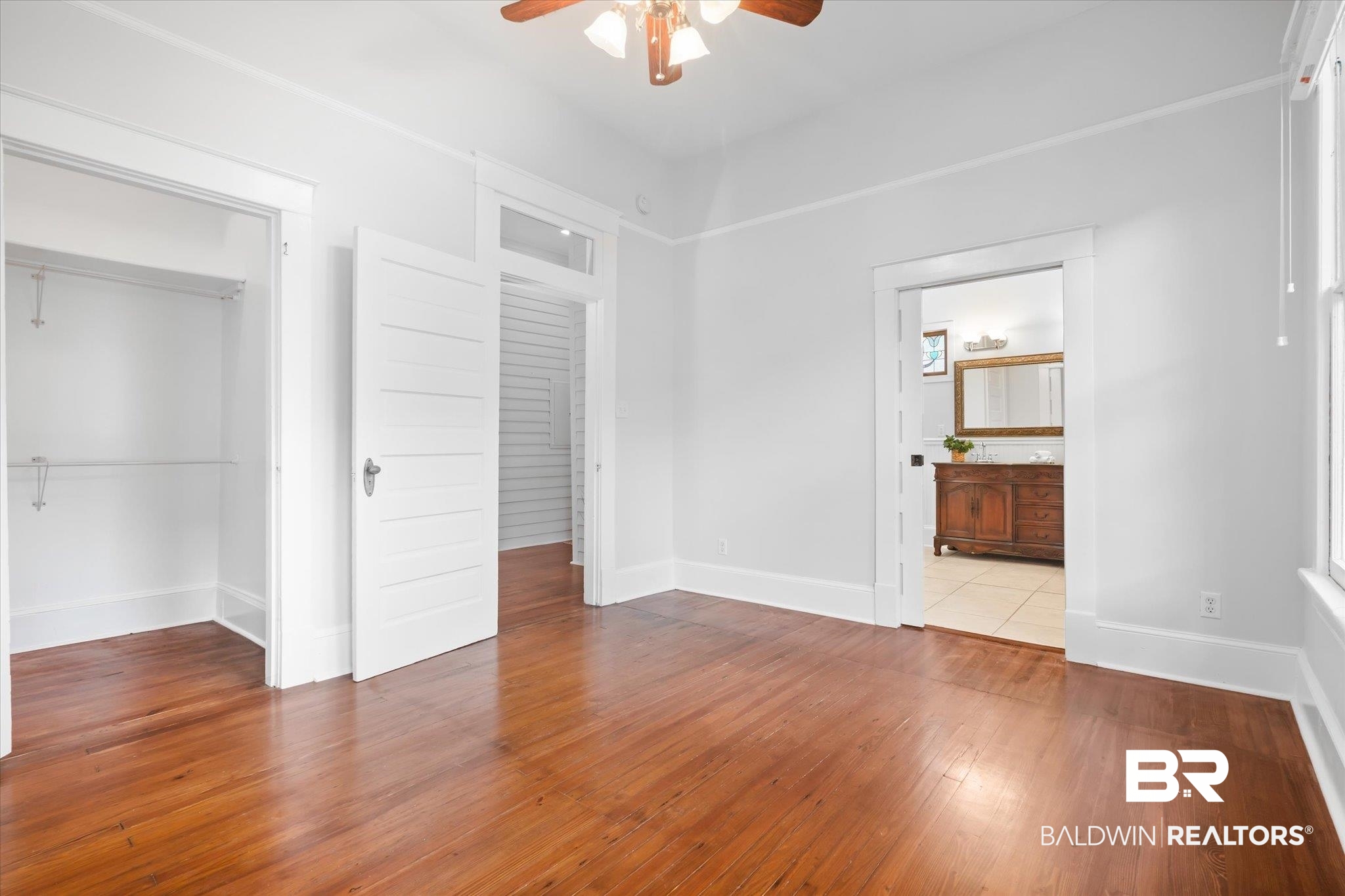 14 South Monterey Street Mobile, AL 36604 - Photo 35 of 41 Unfurnished bedroom featuring connected bathroom, a closet, ceiling fan, and light hardwood / wood-style flooring