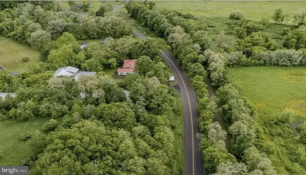 an aerial view of residential house with outdoor space and trees all around