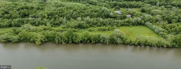 an aerial view of a houses with a yard and lake view