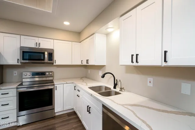 a kitchen with appliances a sink and cabinets