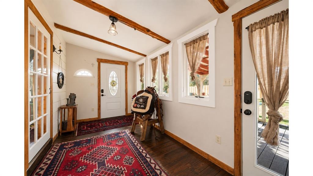 117 Reading Avenue North Center Point, TX 78010 - Photo 7 of 20 Entryway featuring exposed wood-finish beams, rich wood-finish flooring, white walls, and multiple windows