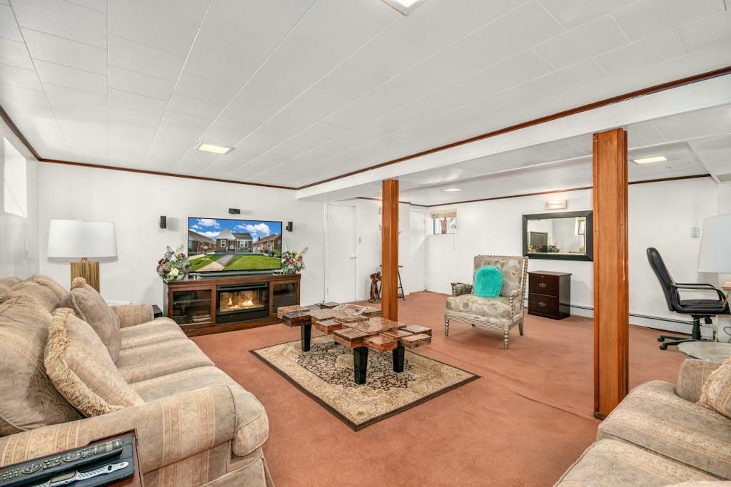 130-13 230th Street Queens, NY 11413 - Photo 5 of 12 a living room with furniture a fireplace and a flat screen tv