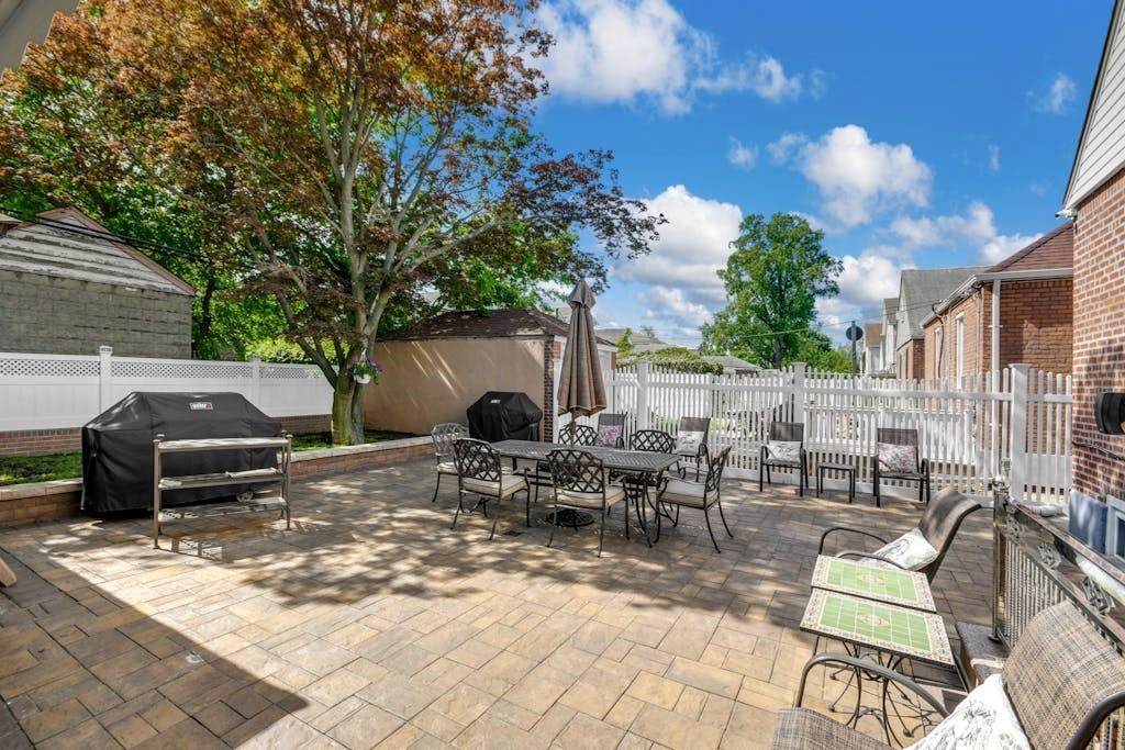 130-13 230th Street Queens, NY 11413 - Photo 10 of 12 a view of a patio with table and chairs and potted plants