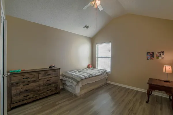a spacious bedroom with a bed and a desk