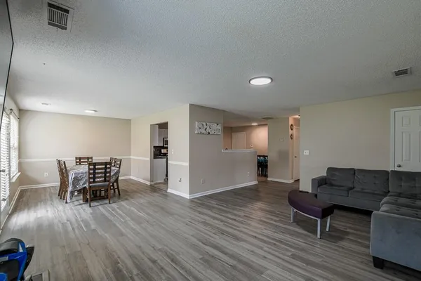 a living room with furniture and a wooden floor