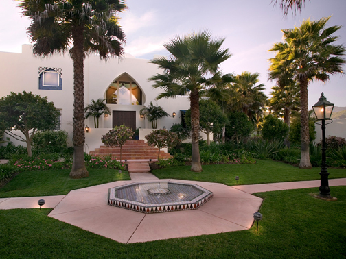 875 Sand Point Road Carpinteria, CA 93013 - Photo 2 of 12 a front view of a house with a yard and palm trees