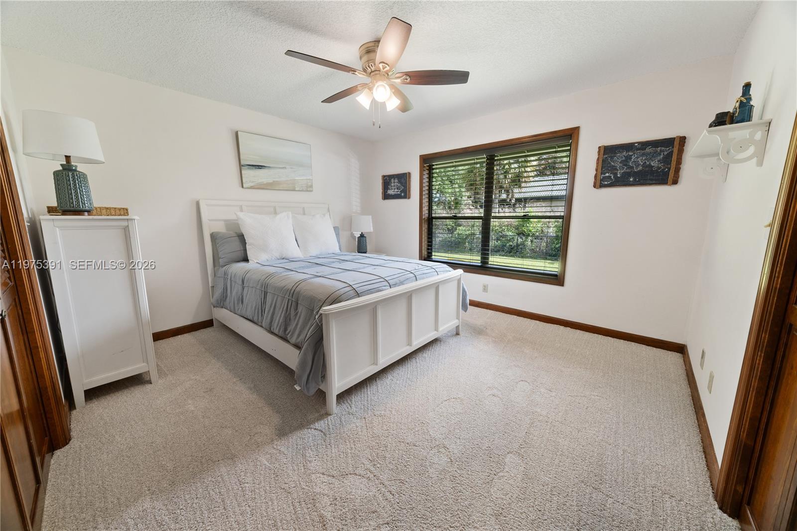 1872 Southeast Colony Way Jupiter, FL 33478 - Photo 23 of 26 a spacious bedroom with a bed and a large window