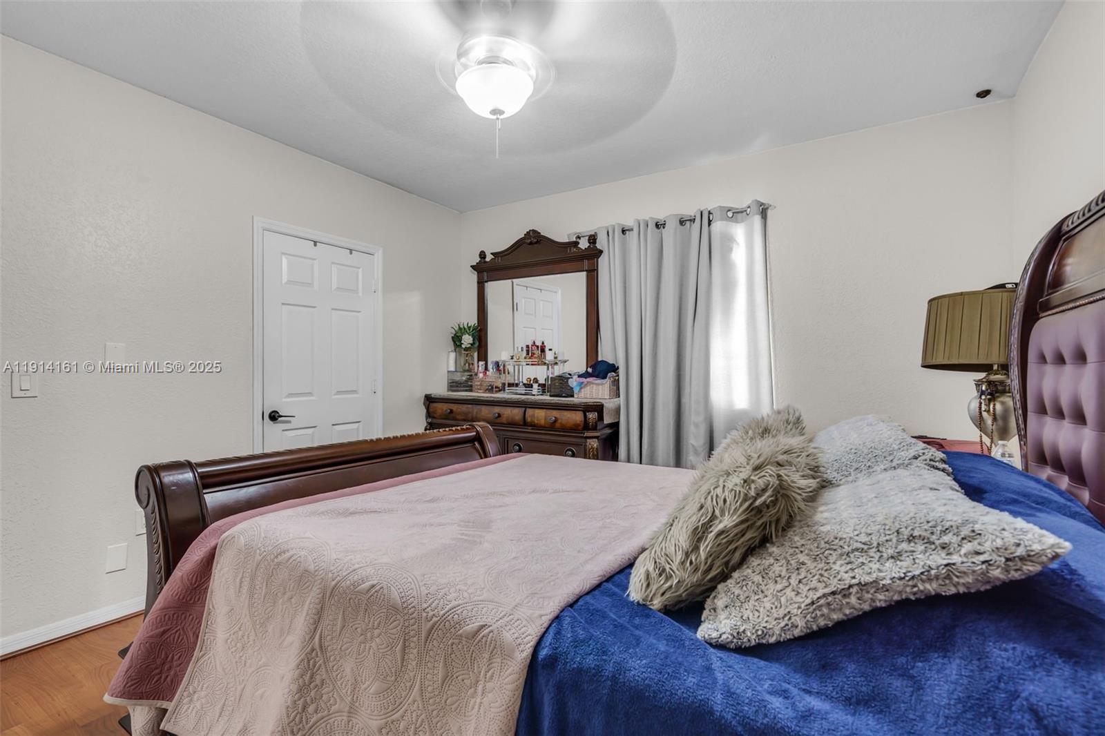 7271 Northwest 174th Terrace, Unit 202 Hialeah, FL 33015 - Photo 12 of 22 a bedroom with a bed and a chandelier