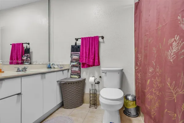 a bathroom with a toilet sink vanity and mirror